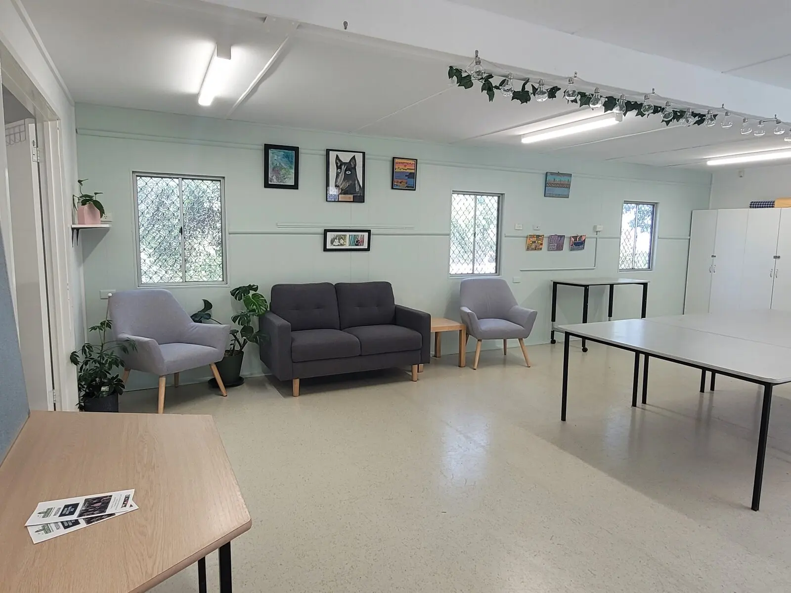 The Banyule Room: a bright, long room with sofas and armchairs at one end and tables at the other