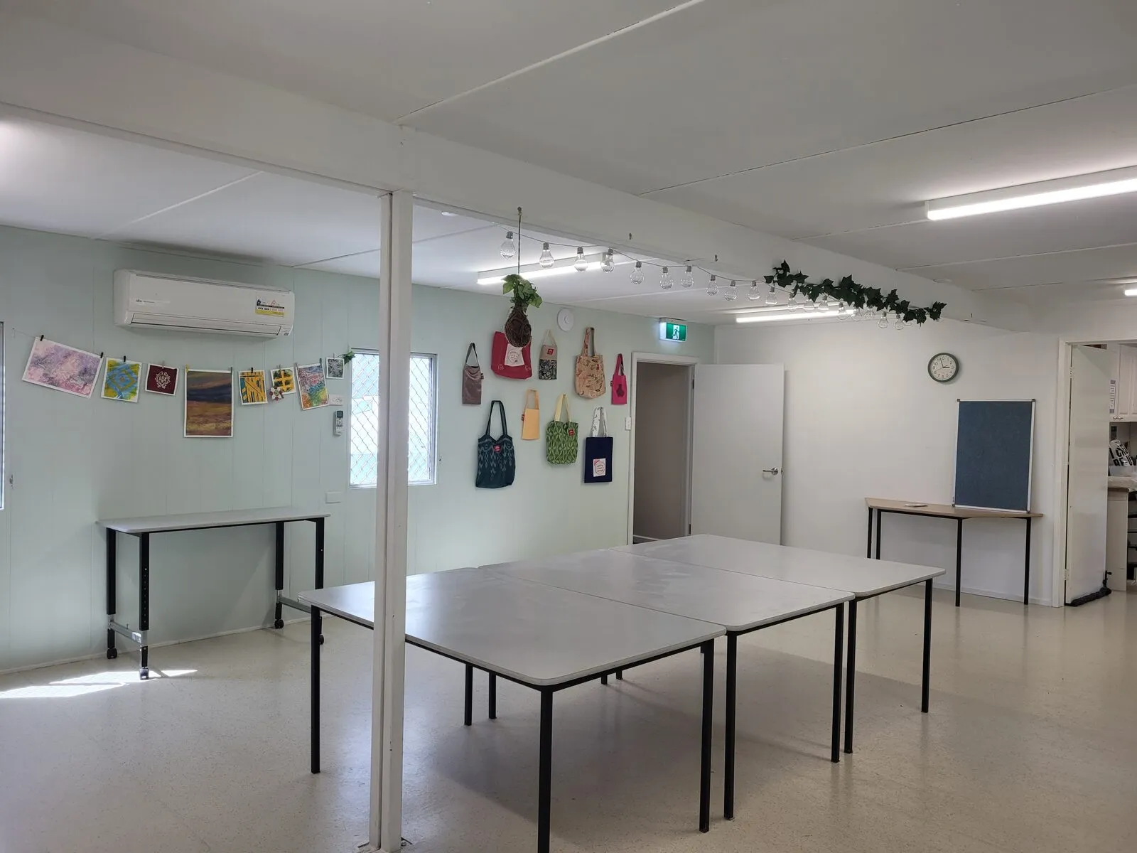 The Eucalypt Room set up with white tables, handmade tote bags hanging along the wall