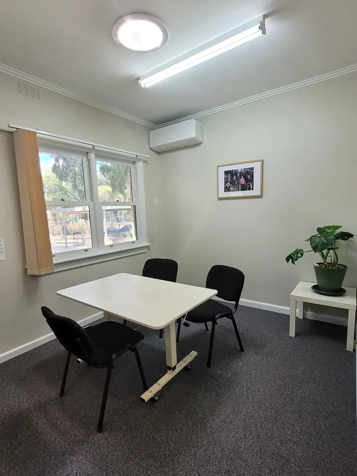 The small meeting room with a table, chairs and a window looking out onto greenery